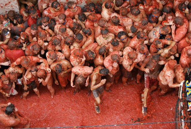 Revellers are covered in tomato pulp during the annual tomato fight in eastern S