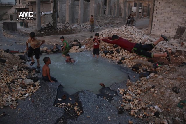 Niños sirios usan como piscin el cráter de una bomba