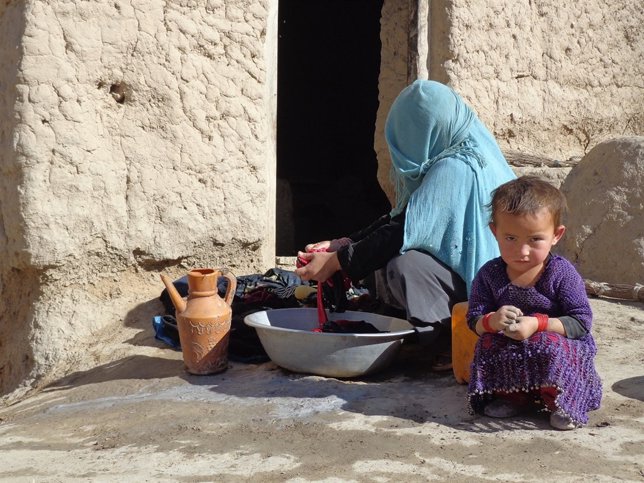 Un madre friega los platos junto a su hija Khalesa