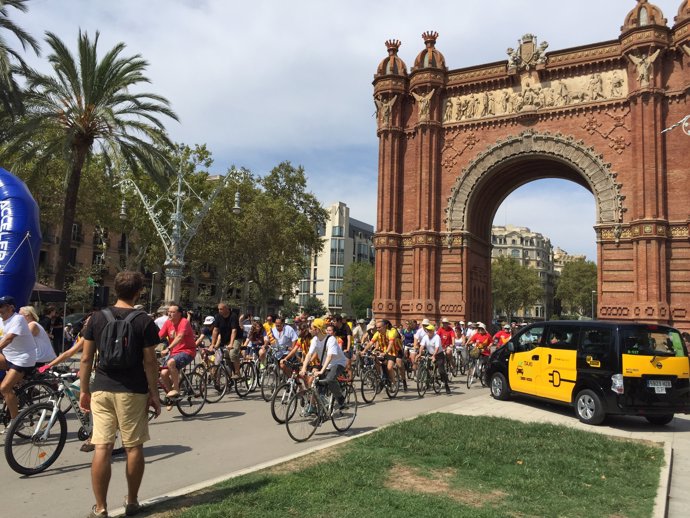 Ciclistas en la avenida Lluís Companys, ante el Arc de Triomf de Barcelona