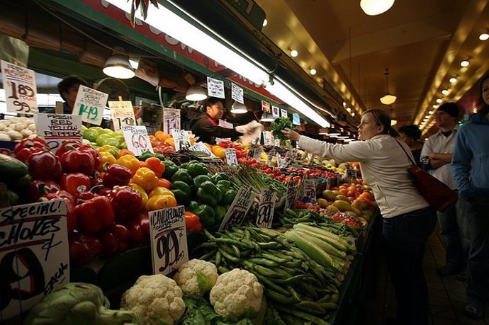 Mujer en el mercado comprando verduras