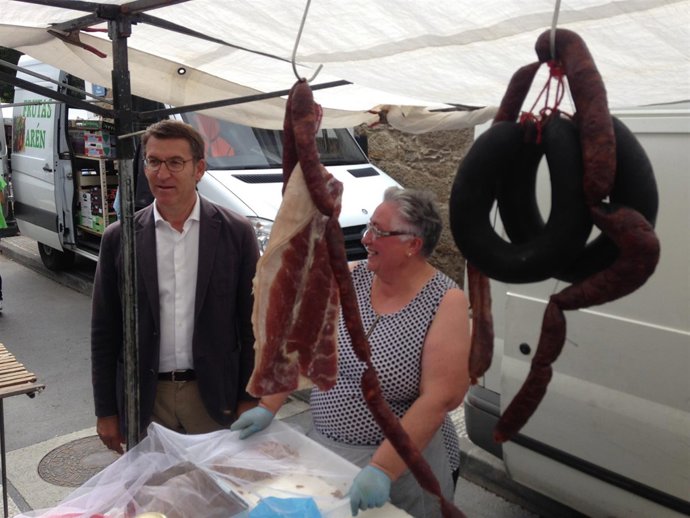 Feijóo en el mercado de Arteixo con una tendera de chorizos y lacones