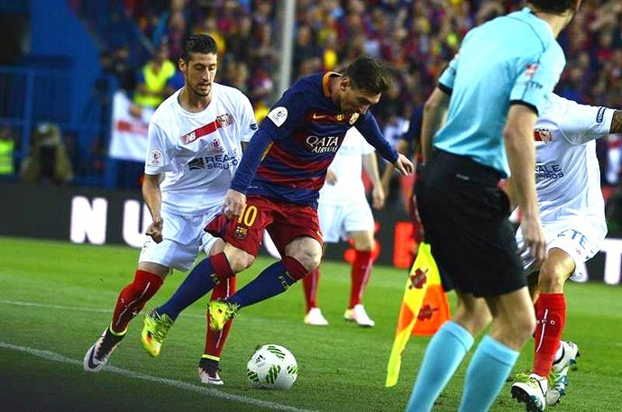 Sergio Escudero, del Sevilla, ante el barcelonista Lionel Messi