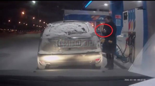 Una mujer enciende un mechero mientras llena el depósito