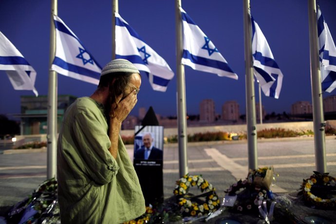 Un hombre llora junto al retrato de Shimon Peres en Jerusalén.