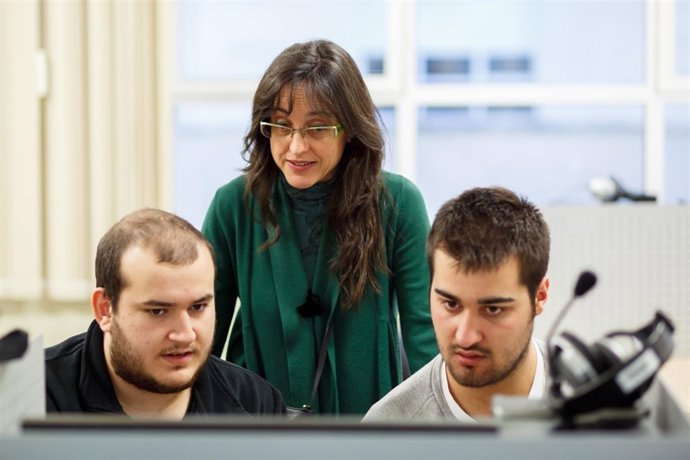 La profesora de inglés Nieves Candela Osés atiende a dos estudiantes.
