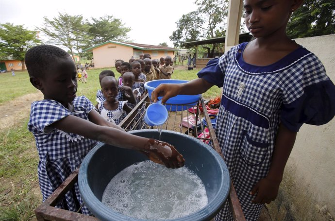 Un niño se lava las manos antes de entrar a clase en Costa de Marfil