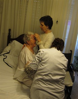 Una usuaria del SAD es atendida por su hija y una cuidadora