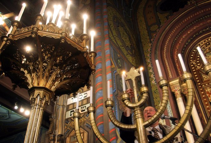 Rabino encendiendo una menorá o candelabro de siete brazos judío