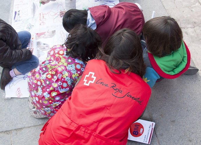 Una voluntaria de Cruz Roja junto a niños