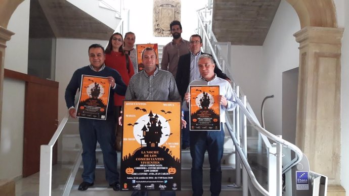 Los comerciantes posan con el cartel de Halloween