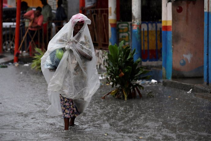 Una mujer caminapor una calle anegada en Haití