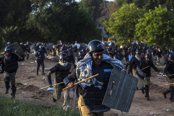 Policías perseguidos por manifestantes opositores en Islamabad