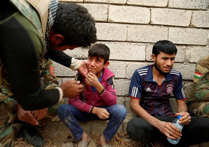 Un niño iraquí habla con un miliciado kurdo tras escapar de zona de ISIS