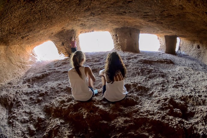 Dos chicas en una cueva del yacimiento de cuatro puertas