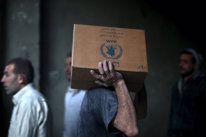 Hombre con una caja de ayuda humanitaria del PMA en Siria