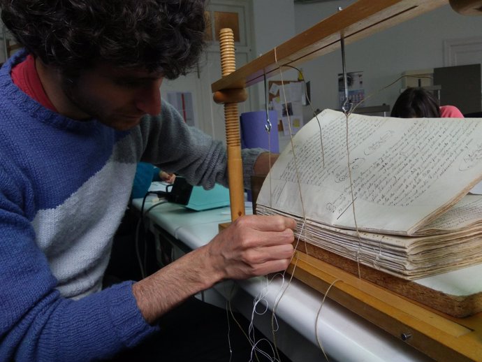 Un alumno de la escuela taller de la DPZ restaurando los libros sacramentales