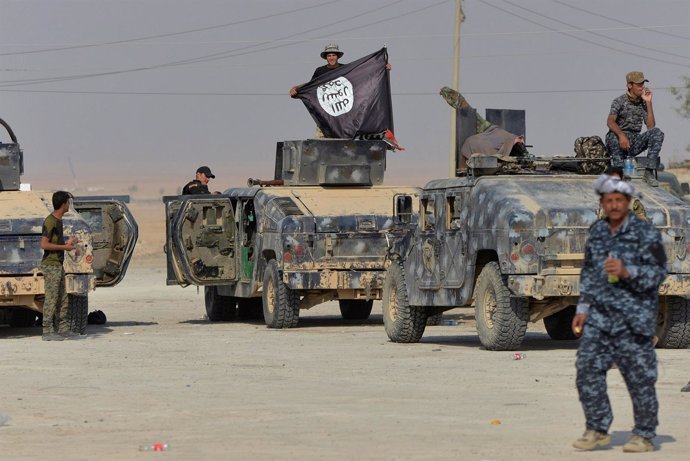 Militares iraquíes posan con la bandera de Estado Islámico