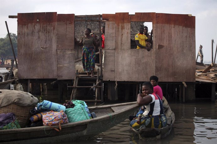 Residentes de la comuniad de Makoko en Laos observan la demolición de viviendas.