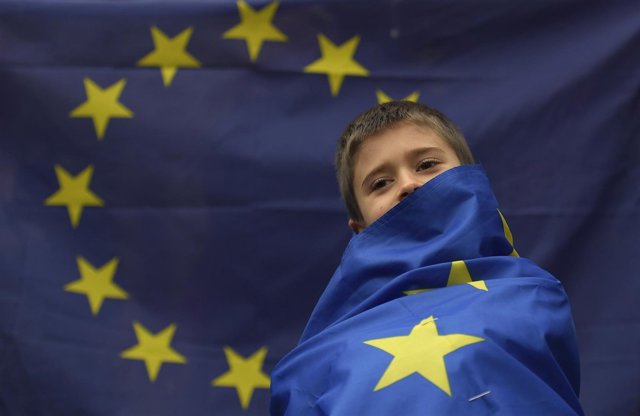 Niño envuelto en una bandera de la UE