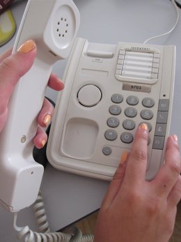 Una joven marcando un número de teléfono