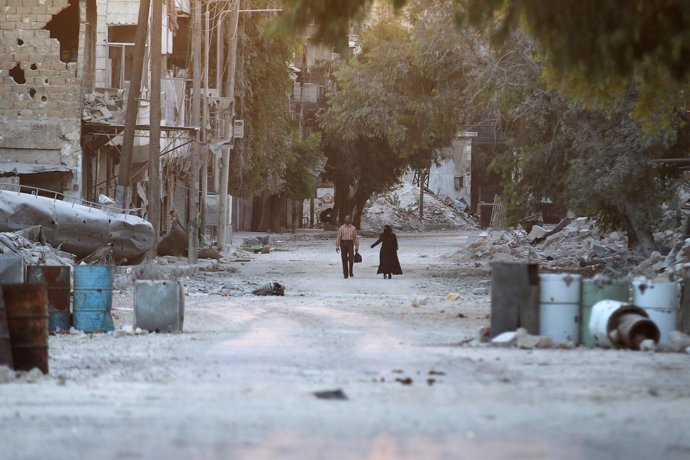 Civiles pasean entre edificios derruidos en un barrio rebelde de Alepo
