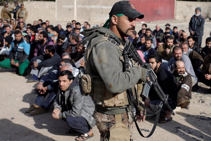 Un soldado comprueba identidades de hombres en Mosul