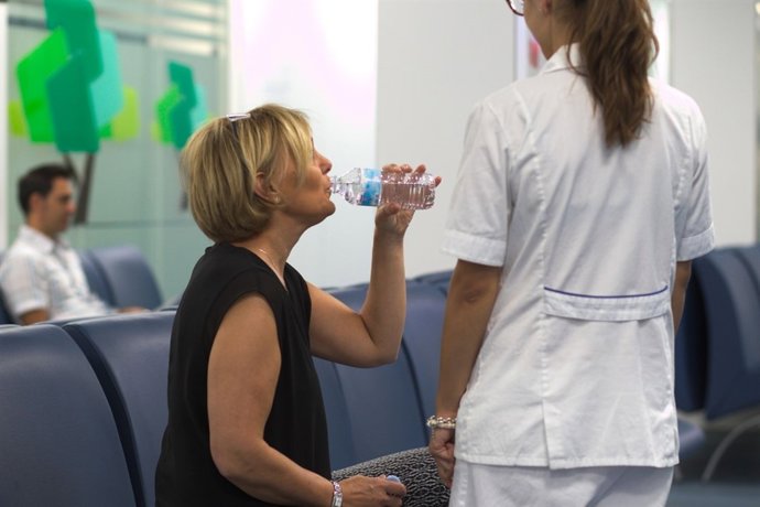 Una mujer bebe agua en Urgencias