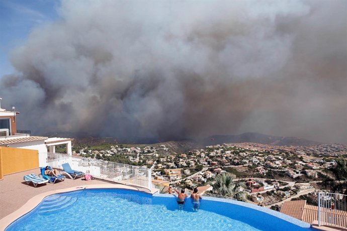 Unos vecinos observan el avance del incendio de Benitatxell 