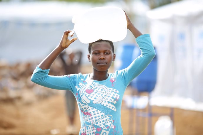 Una adolescente carga agua en el campo de refugiados de Mahama, Ruanda