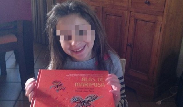 La niña Nadia Nerea posa con el libro 'Alas de mariposa'