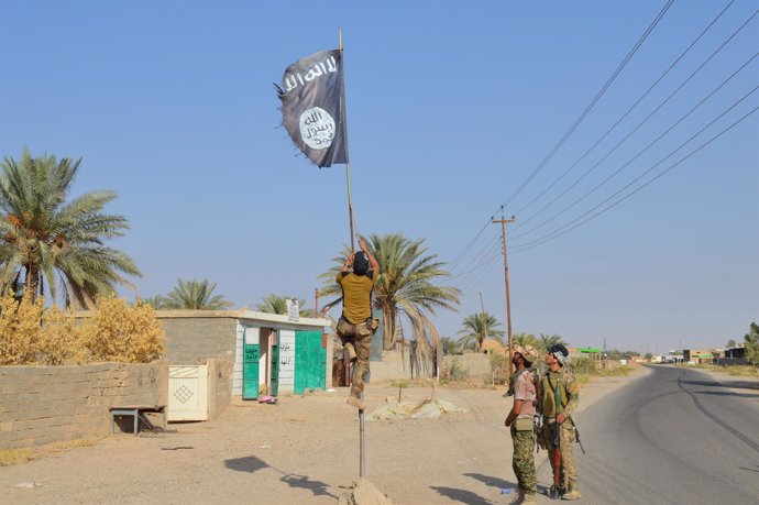 Un militar iraquí descuelga una bandera de Estado Islámico