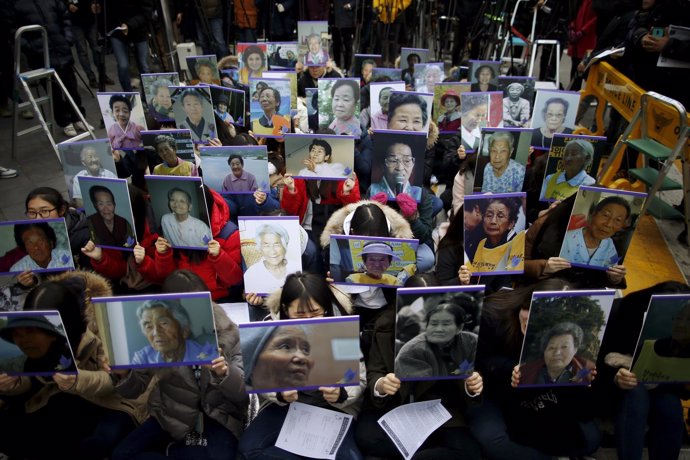 Manifestantes sujetan los retratros de "mujeres para confort"  fallecidas