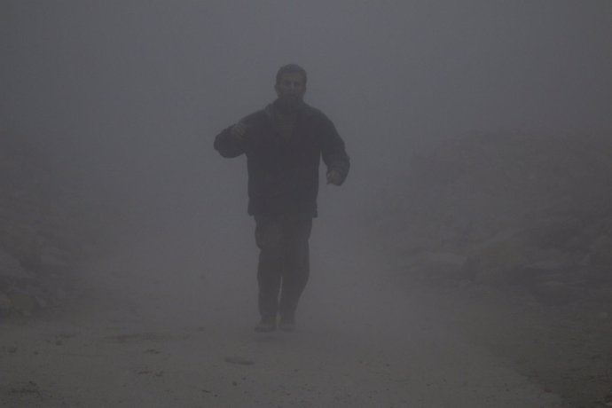 Un hombre camina entre el polvo tras un ataque en la zona rebelde de Alepo