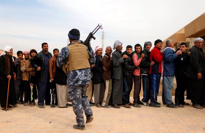 Un grupo de residentes de Mosul hace fila para recibir las ayudas de la ONU.