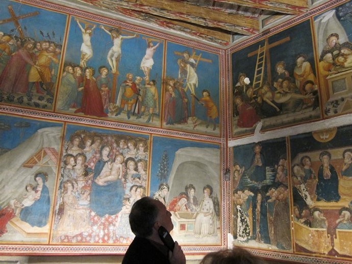 Un visitante ante los murales medievales de la capilla de Sant Miquel del Real