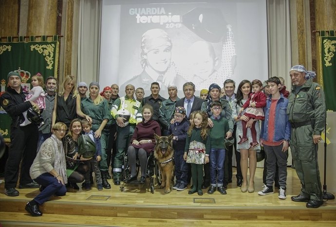 Zoido y el director de la Guardia Civil posan con niños del Calendario Solidario
