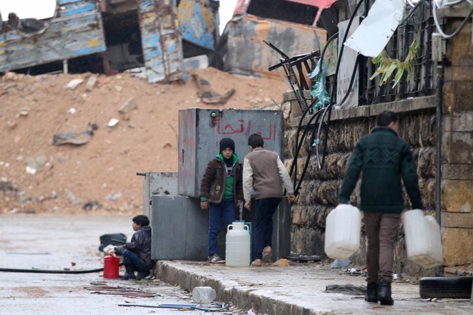 Un grupo de civiles recoge agua en una zona rebelde de Alepo