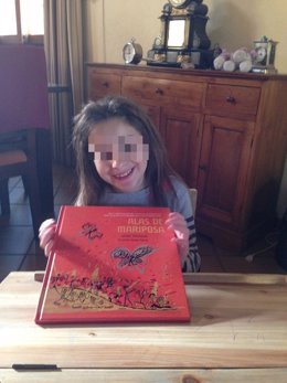 La niña Nadia Nerea posa con el libro 'Alas de mariposa'