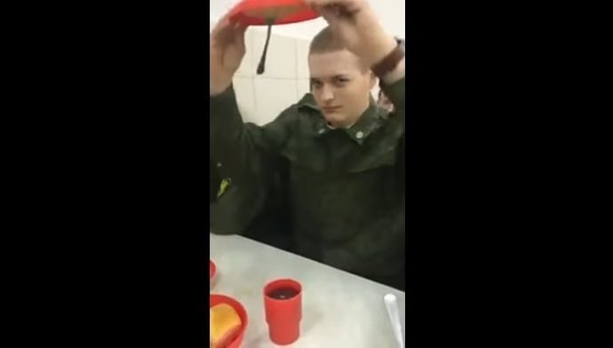 Un soldado demuestra como su comida no cae del plato