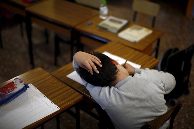 Un niño hace sus deberes en un centro de Cáritas