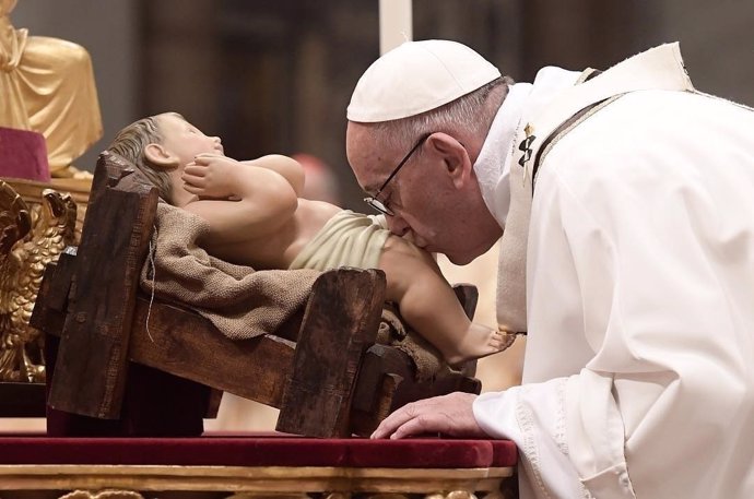 El Papa Francisco besa la imagen del niño Jesús durante la misa del Gallo