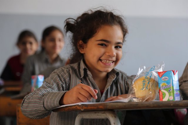 Una niña en el colegio con una de las comidas escolares del PMA