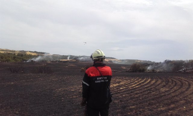 Un bombero afecta un campo quemado en Navarra
