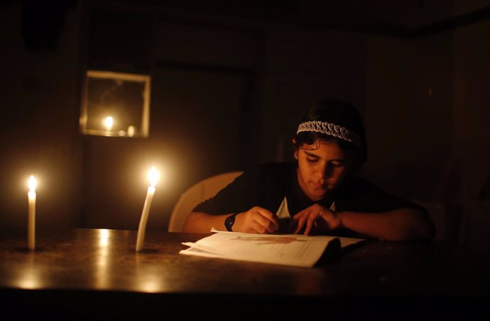 Una niña palestina hace los deberes a la luz de una vela en Gaza