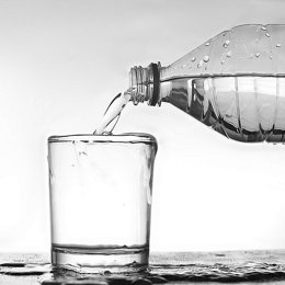 Botella de agua vertiendo a un vaso