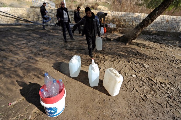 Personas recogen agua en Damasco