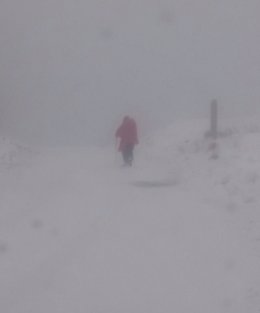 Peregrina caminando en la nive en Roncesvalles