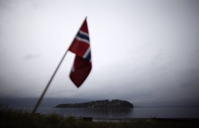 A Norwegian flag is placed on a memorial site on the shore of Tyrifjorden lake