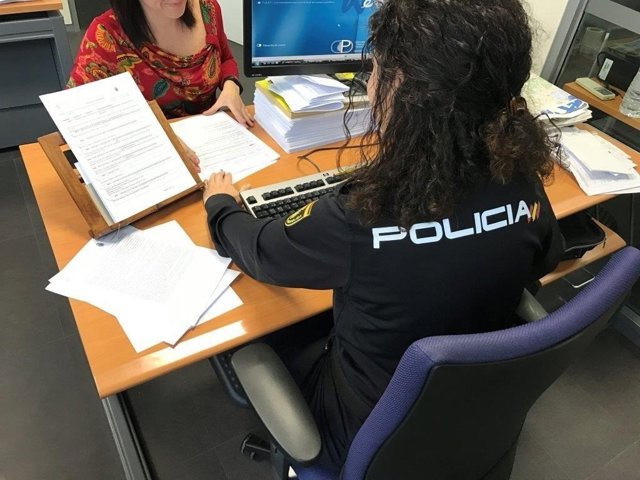 Una agente atiende a un mujer en la Comisaría de Elda